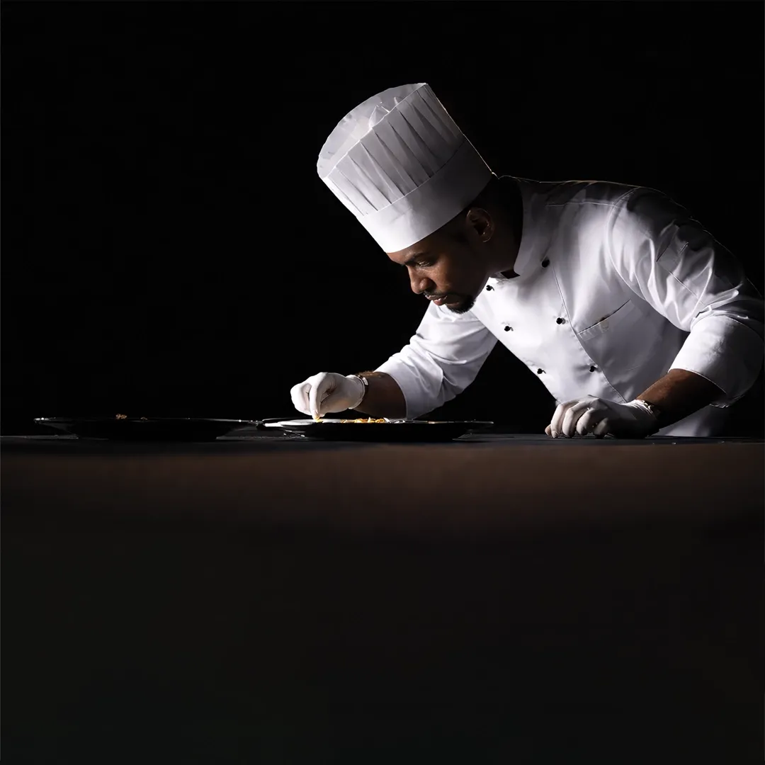 Chef de Partie preparing gourmet dishes in hotel kitchen
